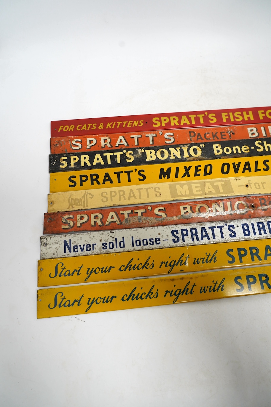 Nine mid century Spratt’s tinplate advertising shelf strips, length 52cm. Condition - poor-fair